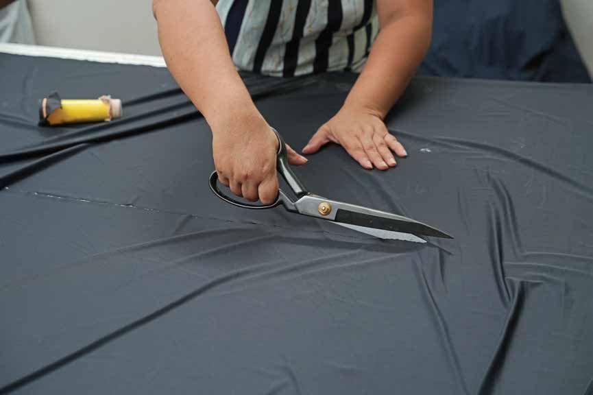 Fabric being cut by hand
